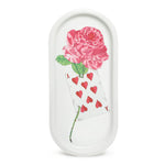 The Ace of Cards Rose Tray features a hand-painted rose illustration on high-quality enameled porcelain. This beautifully crafted tray, made using traditional plaster molds, showcases intricate craftsmanship and design. The tray is dishwasher safe for easy care and maintenance. The image highlights the elegant 14-inch length and 6-inch width of the tray, with the delicate rose illustration applied by hand in the Parisian workshops of Marin Montagut.