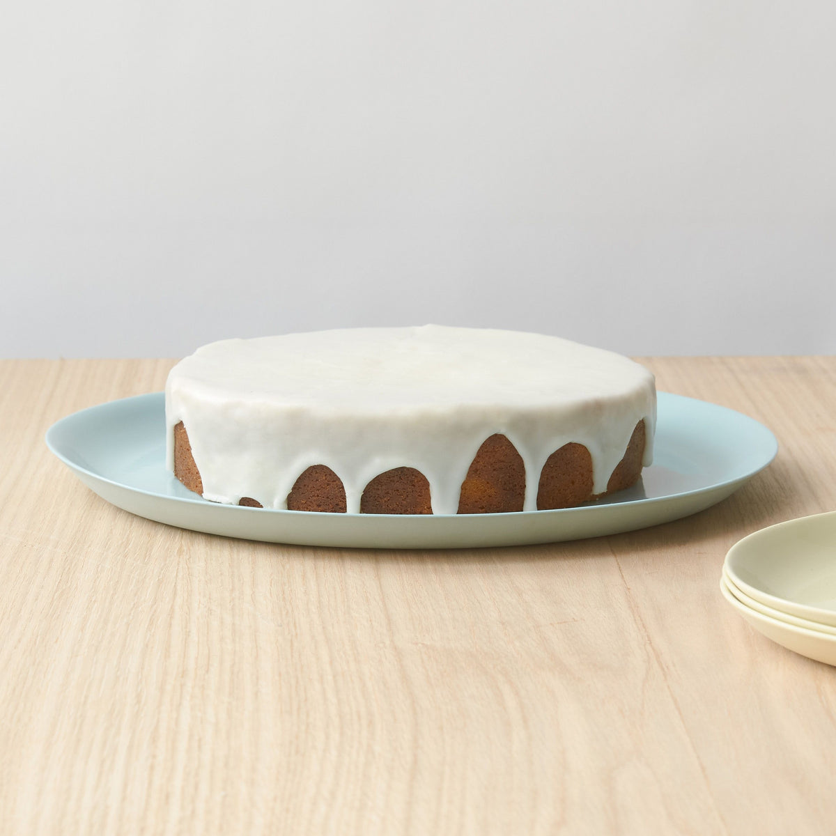 Charger Plate in porcelain, perfect for serving cakes or as a multi-use platter. Features smooth stone-like exterior and clear glazed interior.