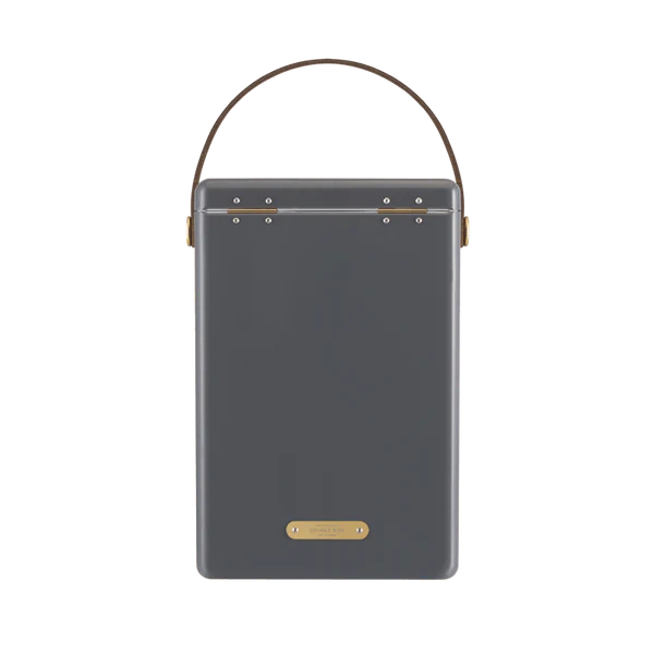 FIELDBAR Drinks Box hardcase cooler with leather handle and brass-coated hardware, showcasing its sleek design and Pantone 10C color, placed on an outdoor surface. Drinks Box / Oyster Grey
