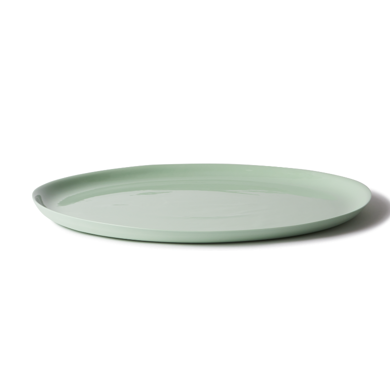 Handmade pistachio porcelain cheese platter, perfect for cheese, charcuterie, or oysters, with a smooth, stone-like exterior.