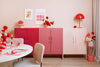 Pink and white cabinets with decorative items in a room setting.