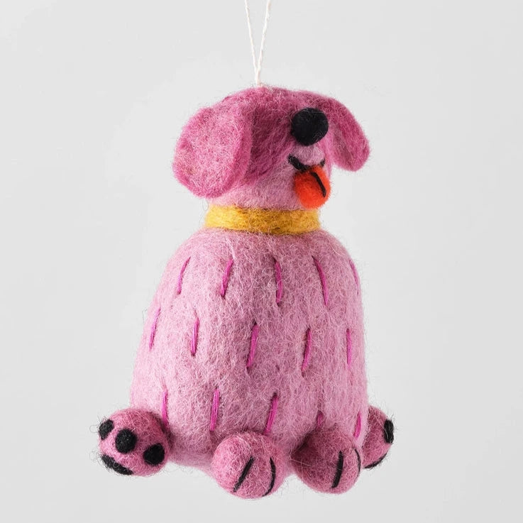 tina a pink felt dog ornament. Cartoon like she is sticking out his tongue and sitting up right. Eyes are closed and have a black button nose 