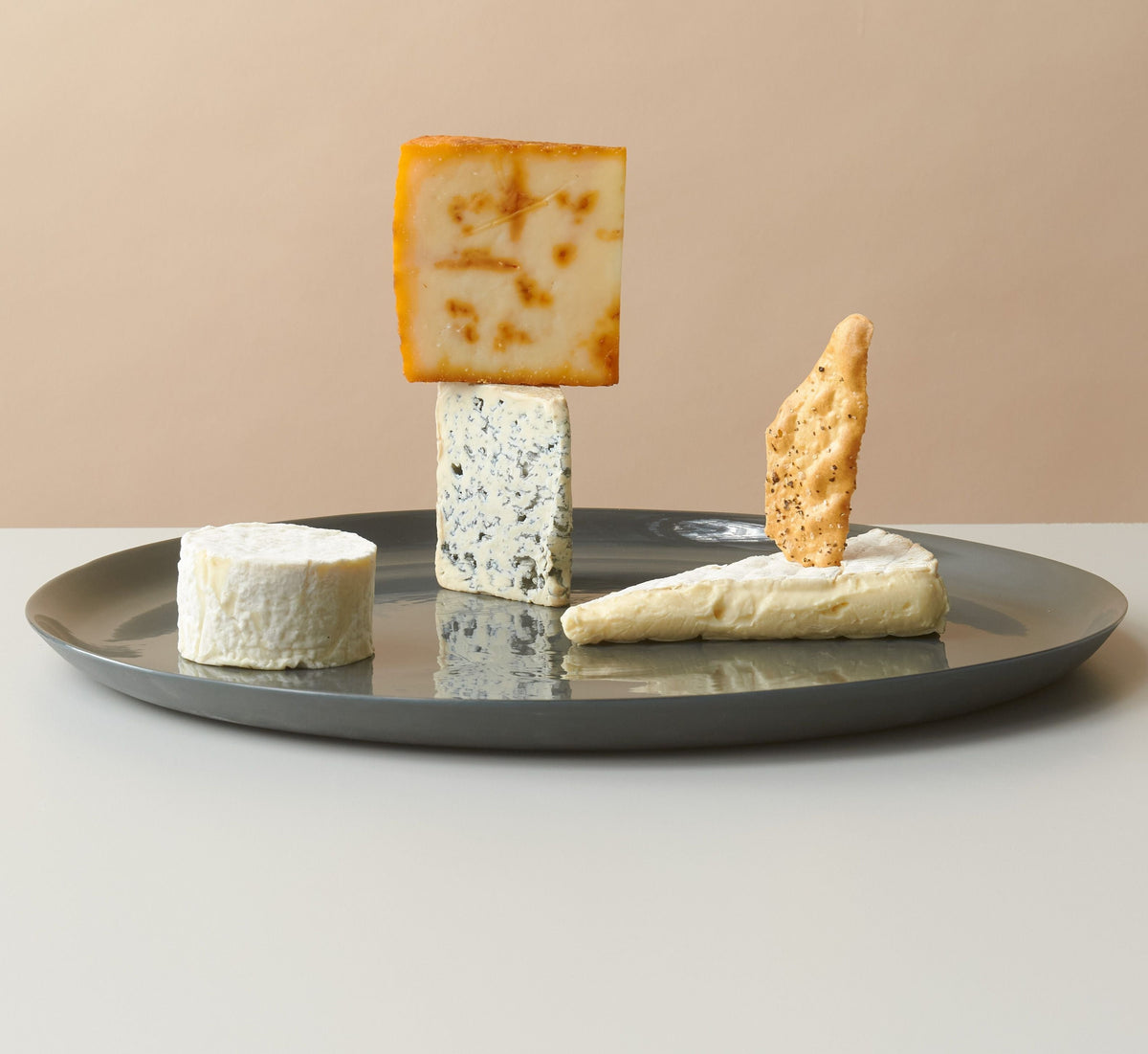 Handmadeporcelain cheese platter, perfect for cheese, charcuterie, or oysters, with a smooth, stone-like exterior.