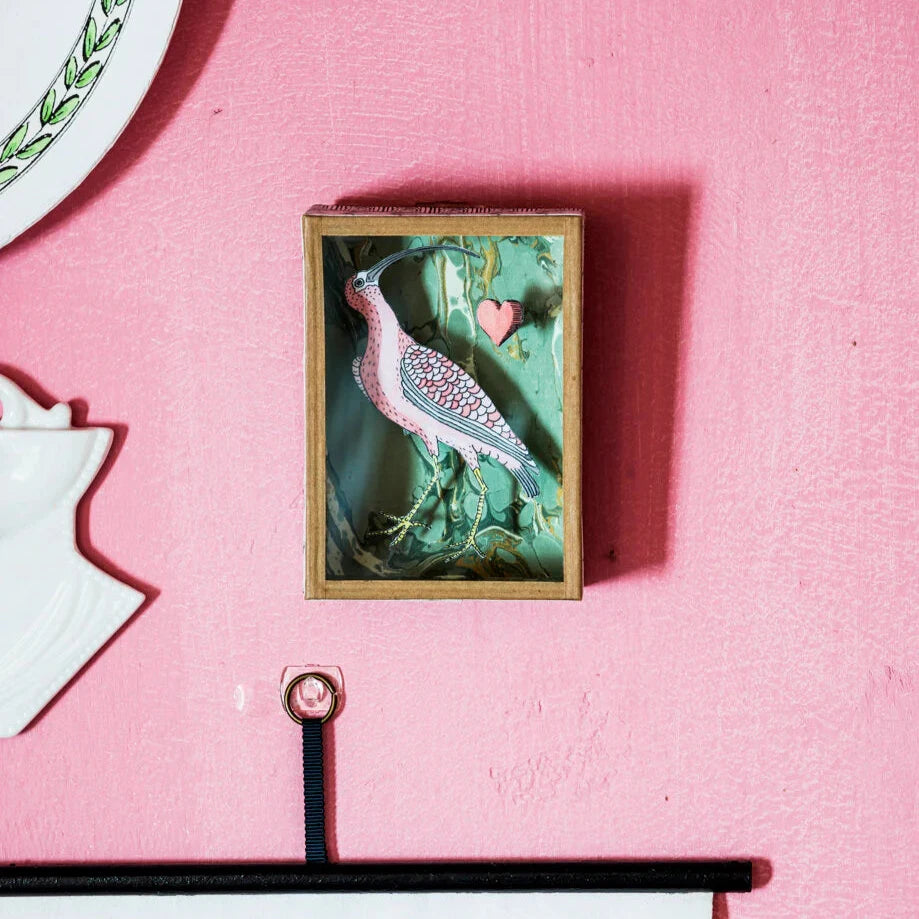 "Hand-painted Petite (The Bird From Elsewhere) Shadow Box by Marin Montagut, featuring a bird inside a glass-enclosed papier-mâché display, handcrafted in Paris. Dimensions: 4.33x3.15x1.42 inches."