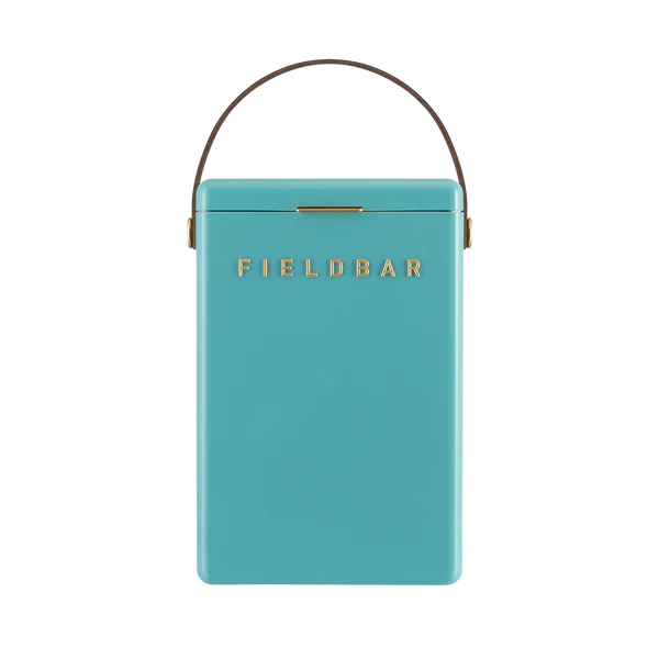 FIELDBAR Drinks Box hardcase cooler with leather handle and brass-coated hardware, showcasing its sleek design and Pantone 2241 color, placed on an outdoor surface. Drinks Box / Bazaruto Blue