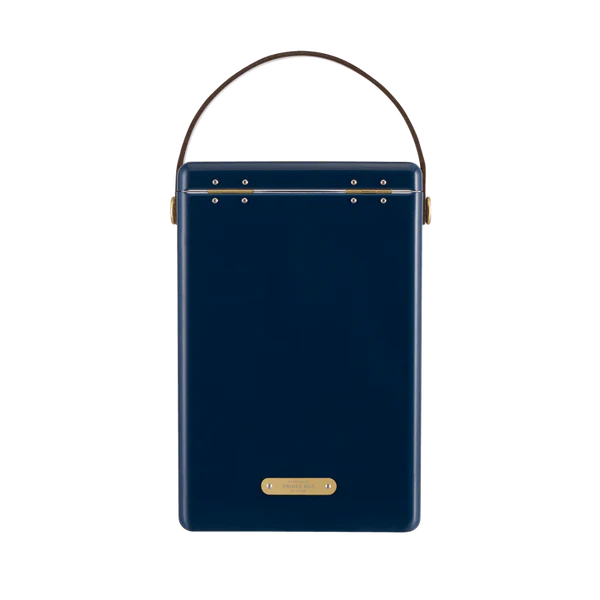 FIELDBAR Drinks Box hardcase cooler with leather handle and brass-coated hardware, showcasing its sleek design and Pantone 10C color, placed on an outdoor surface. Drinks Box / Sea Boat Blue